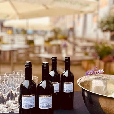 Vins et verres préparés pour un apéritif en extérieur, sur le site de Tour & Taxis