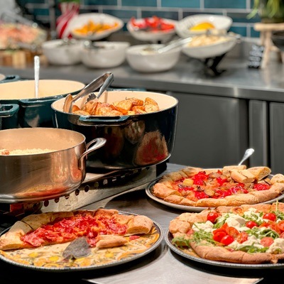 Buffet salé du brunch : pinsas, pommes de terre rôties et plats chauds en casseroles de cuivre